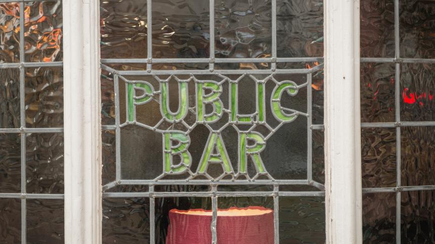 A photograph of a British pub's lead window, showing the words 'Public Bar'.