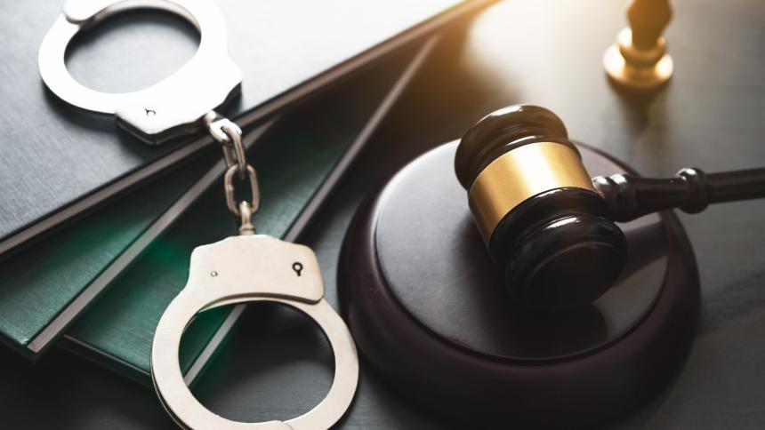 A photograph of police handcuffs and a gavel