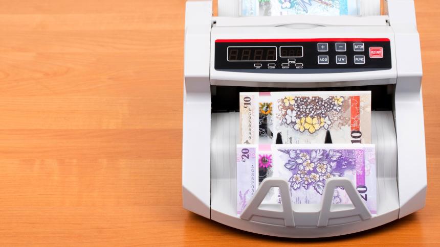 A photograph of Northern Irish banknotes in a bank counting machine