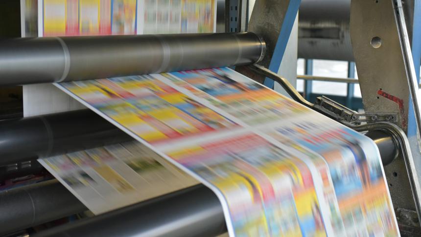 A photograph showing newspapers being printed