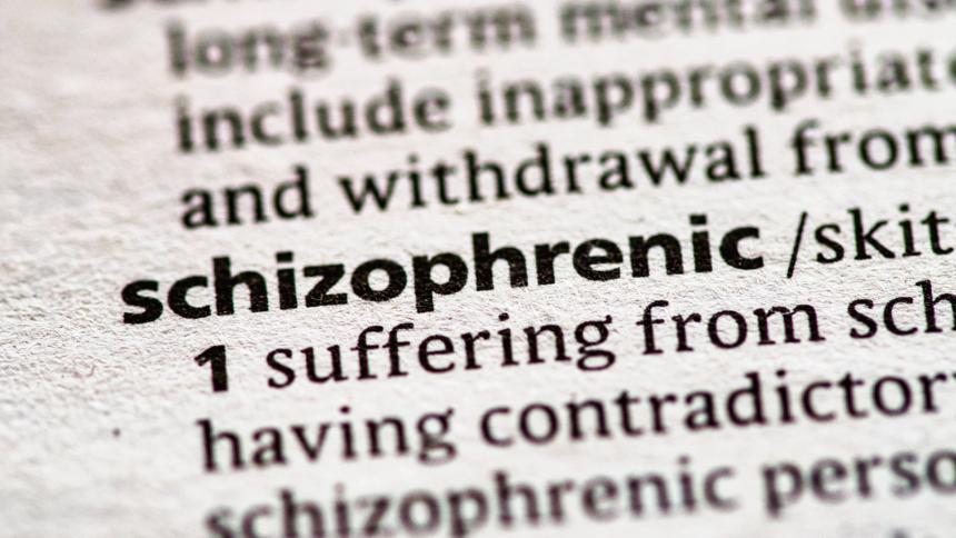 A close up photo of the word 'schizophrenic' in a dictionary.