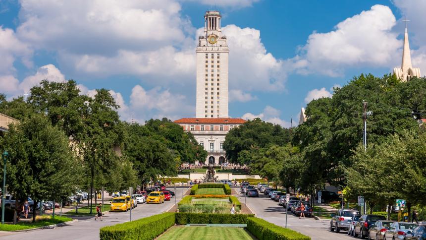 A photograph of the University of Texas (UT) Main Building tower against blue sky in Austin, Texas