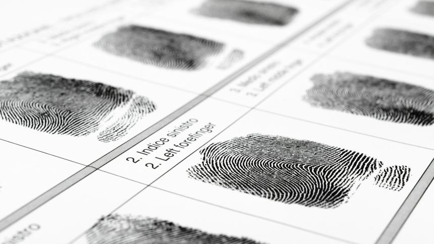 A stock photograph showing fingerprints being collected as evidence.