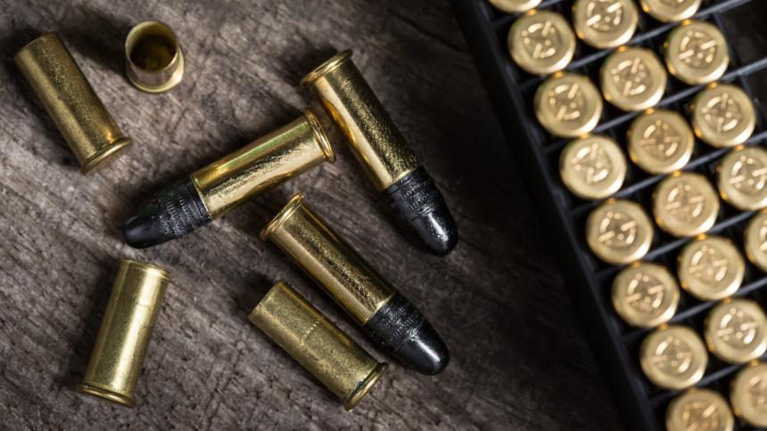 A photograph showing small caliber cartridges on a wooden background