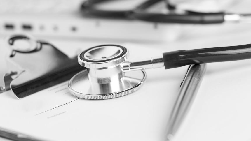 A photograph of a doctors stethoscope and a silver pen