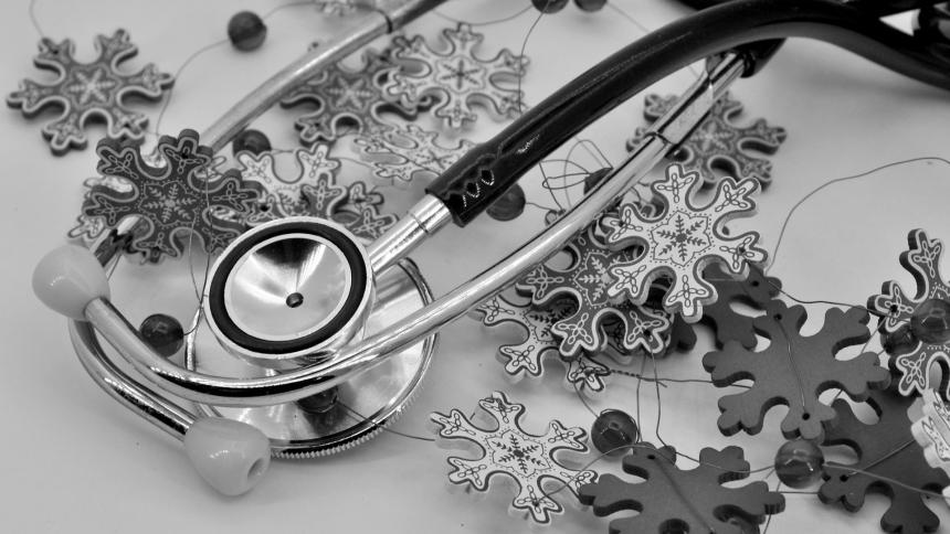 A photograph of a medical stethoscope surrounded by Christmas decorations