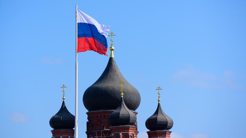 A photograph of the Russian flag flying next to church domes