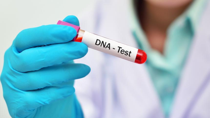 A photograph of a person holding a DNA test