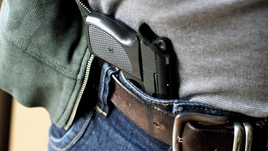 A photograph showing a gun tucked into a pair of jeans as a concealed carry