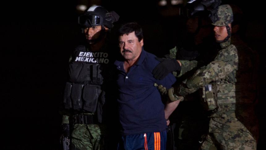 El Chapo apprehended by two Mexican soldiers in camouflage gear