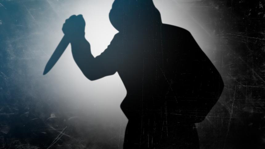 A stock photo showing a shadow of a person with a knife