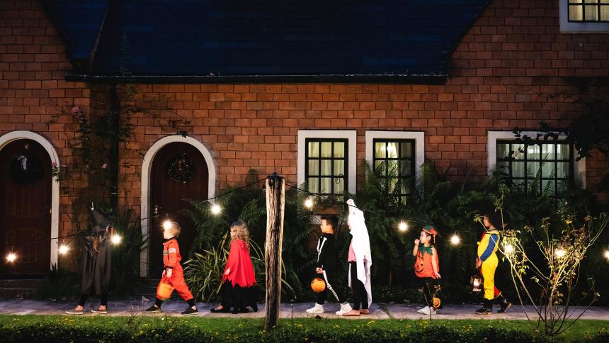 A line of children dressed in costumes trick or treating