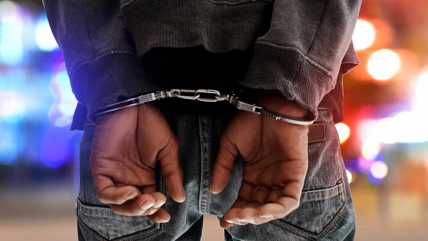A photograph of a man in handcuffs