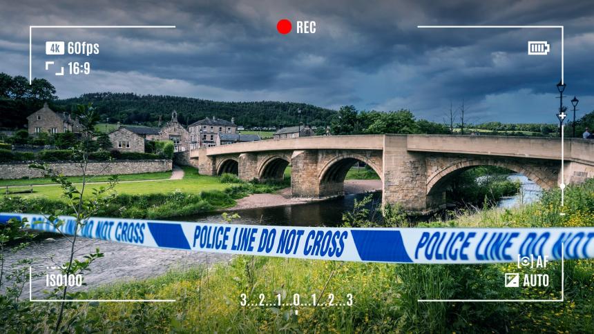 A CGI graphic showing police tape in front of a road bridge at Rothbury, Northumberland