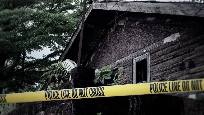 A stock image of a log cabin with police tape