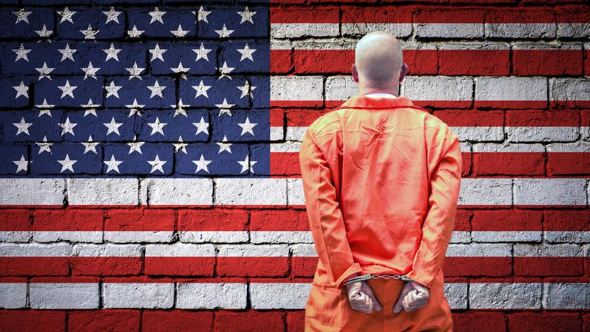 A prisoner in an orange jumpsuit with his hands cuffed behind his back