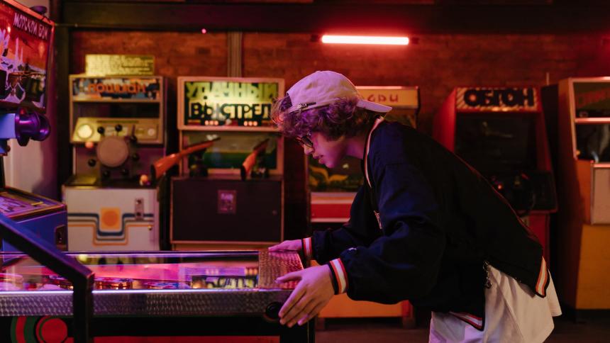 A young person playing pinball