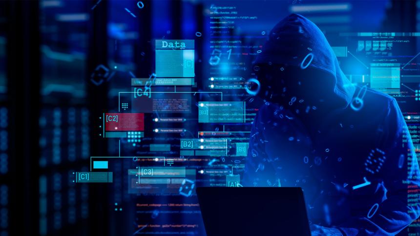 A hooded figure looks at a laptop surrounded by code and data warnings
