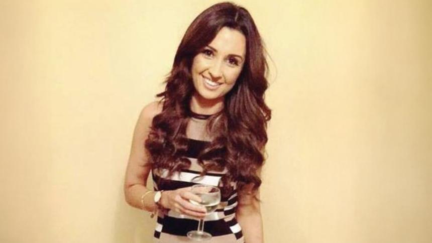 Nadine Lott smiling and holding a glass of wine