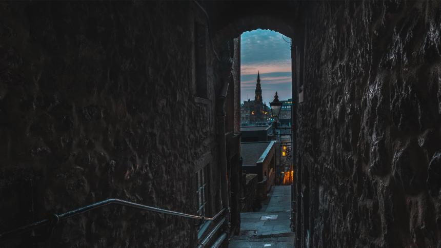 A twilight view of Edinburgh from a small, dark alley