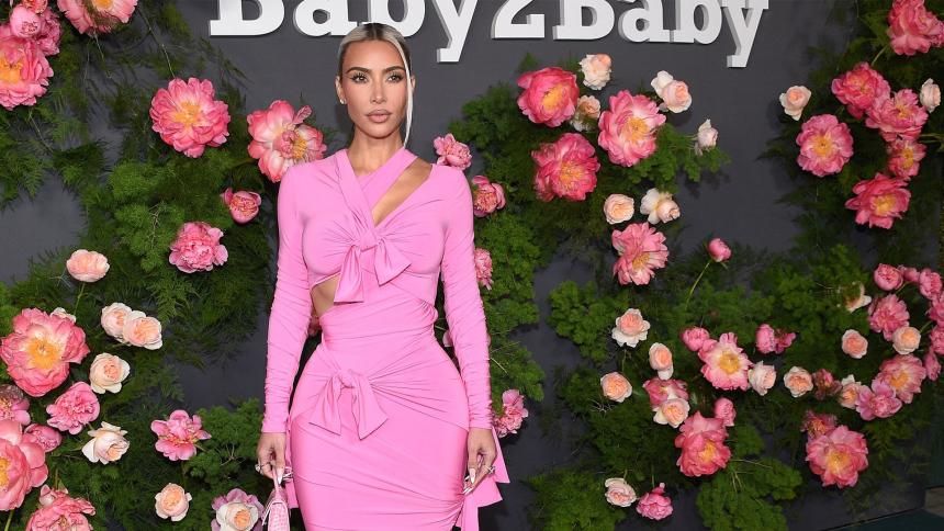 Kim Kardashian wearing a pink dress while posing for photos outside the Baby2Baby annual gala