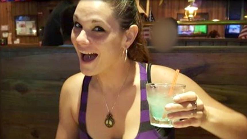 Monica Hoffa smiles while holding a drink in a bar