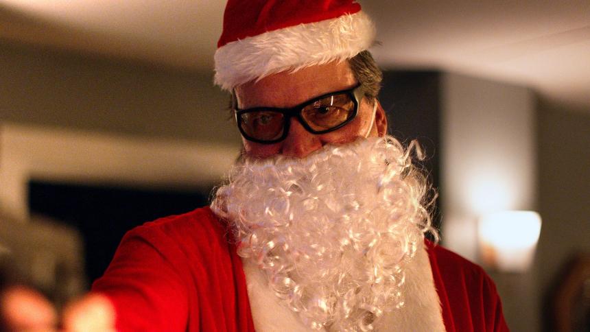 An actor dressed as Father Christmas wielding a gun