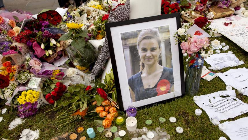 A photo of Jo Cox next to flowers, notes and candles at an impromptu memorial site