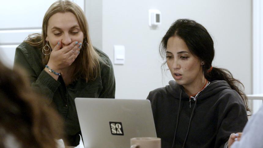 Two women working for SOSA look shocked while looking at a laptop