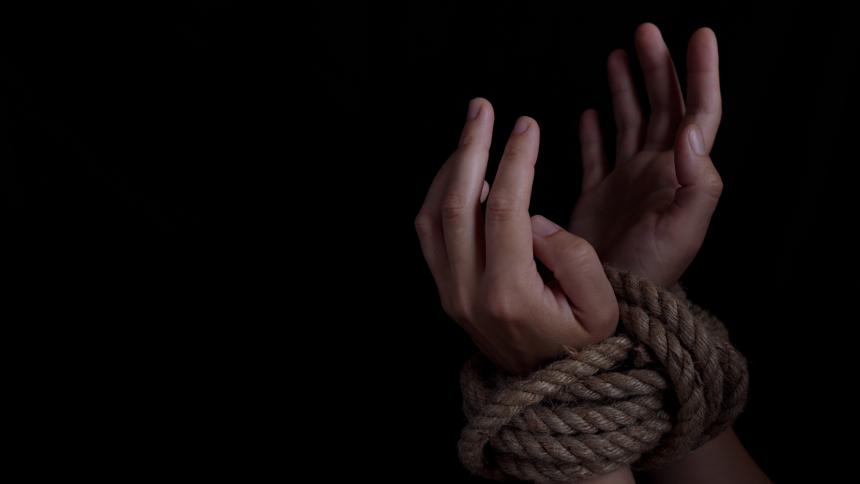 Stock image of a woman's wrists tied with rope