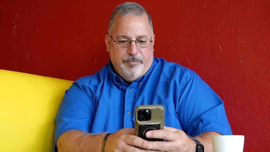 Tony Godwin using a smartphone