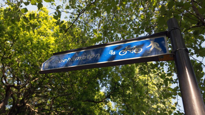 A sign for Roehampton underneath some trees