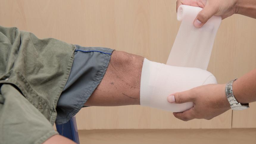 A man bandaging an empty leg